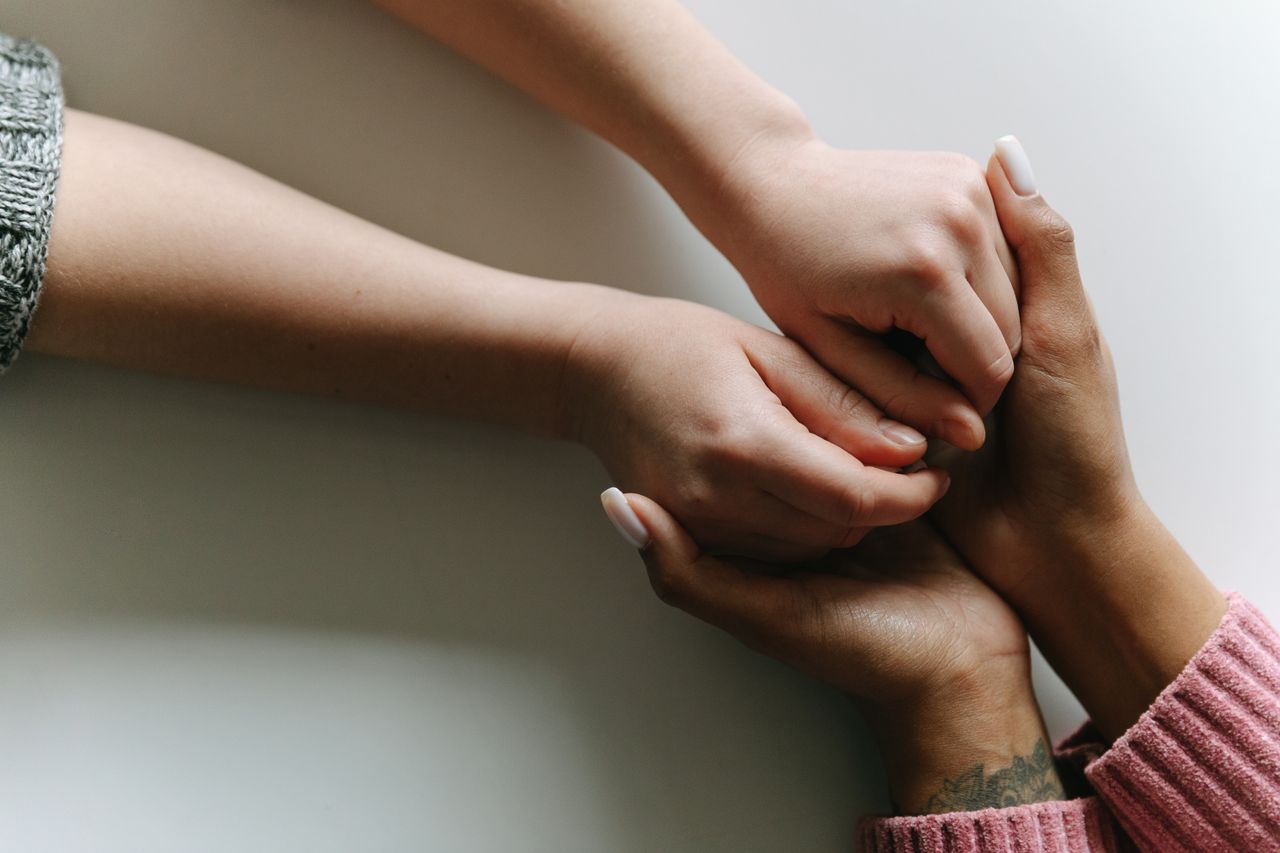 about-02 Close-up of diverse hands holding, symbolizing care, support, and friendship.